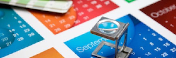 A printers eye glass sitting on a colourful calendar A printers eye glass sitting on a colourful calendar